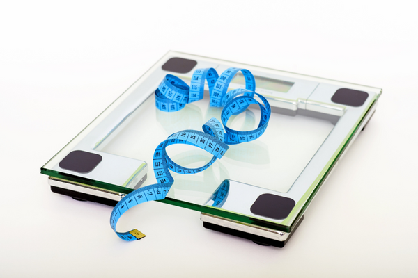 A scale with a measuring tape, perfect for tracking your progress and measuring your fitness goals.