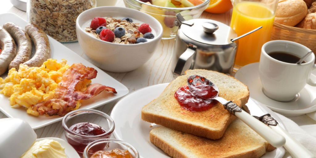 A breakfast table with toast, eggs, and other breakfast foods.