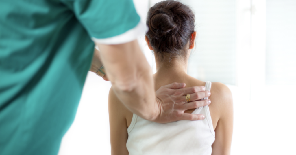 A chiropractor soothingly massages a woman's back, providing relief and relaxation.