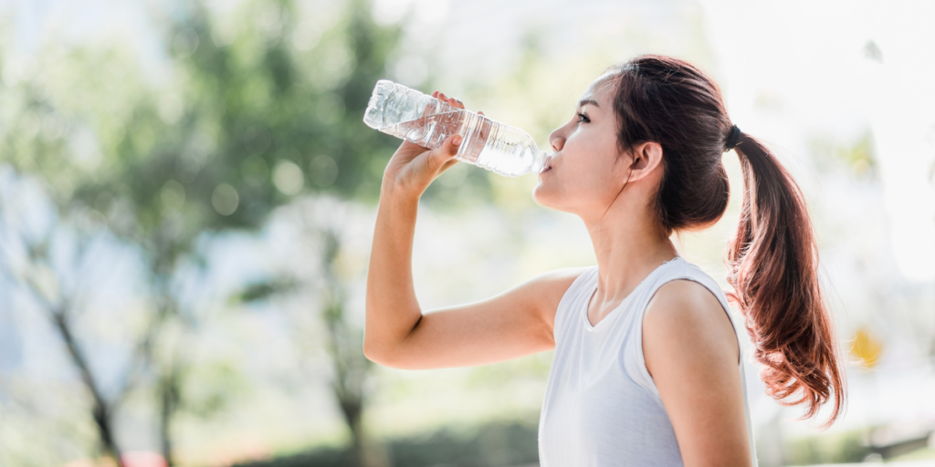 Female drinking water from a bottle.